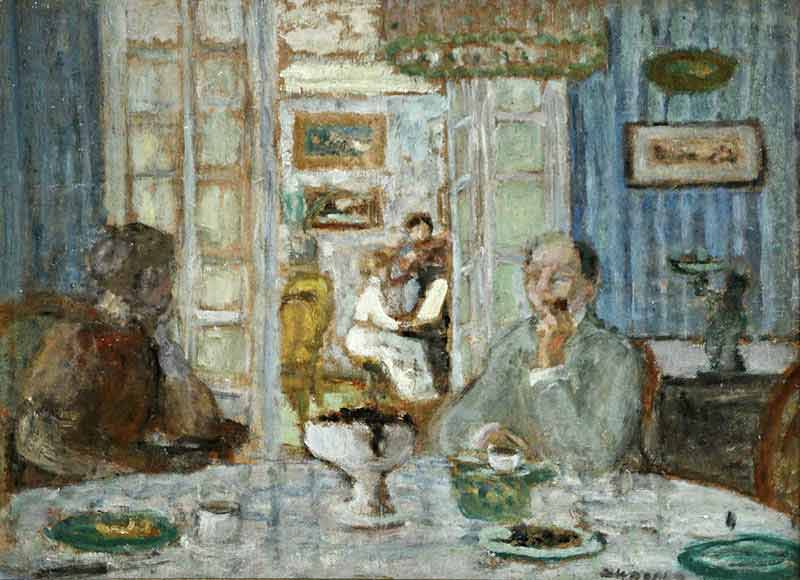Man and woman sat at table to foreground with young woman playing piano through open doors to background.